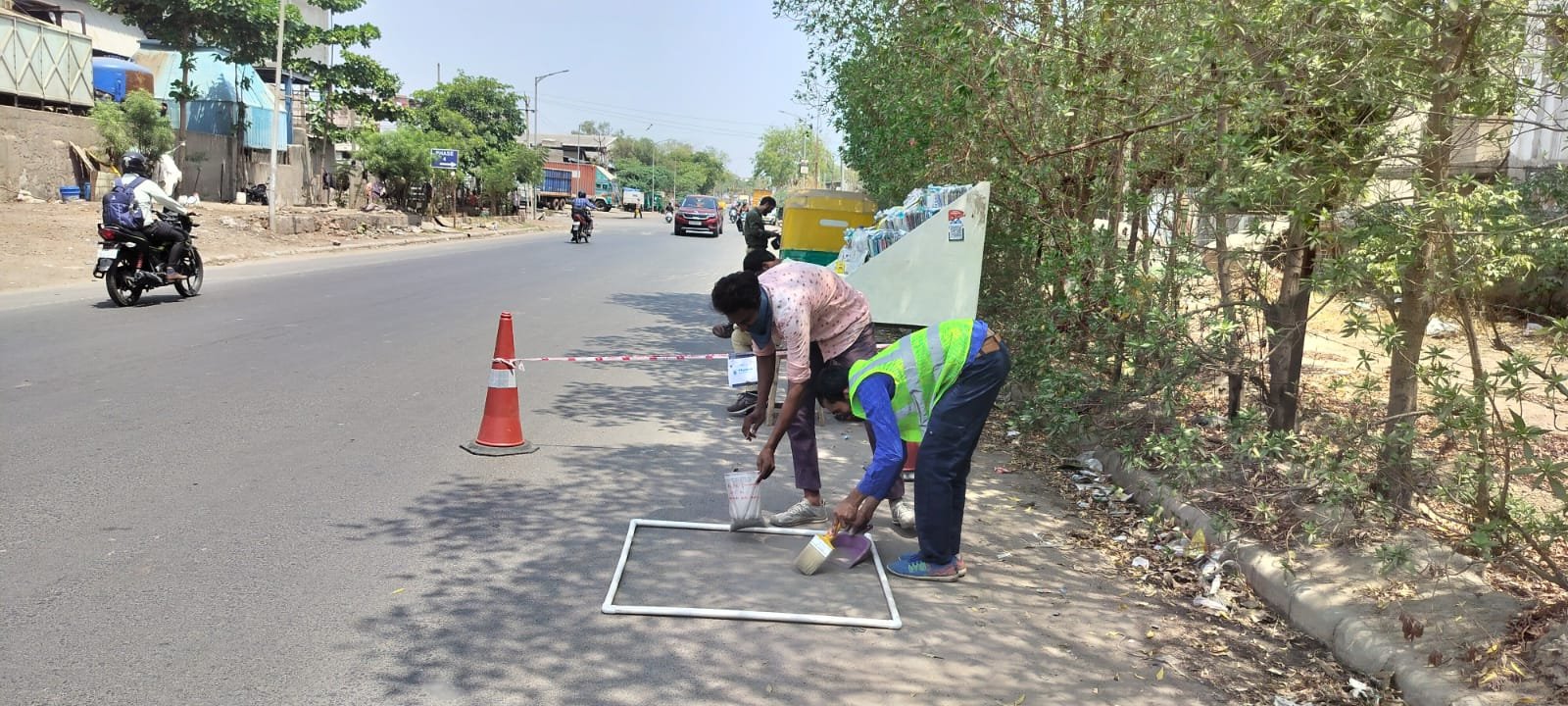 Team brushing loose road surface material into a labeled sample container